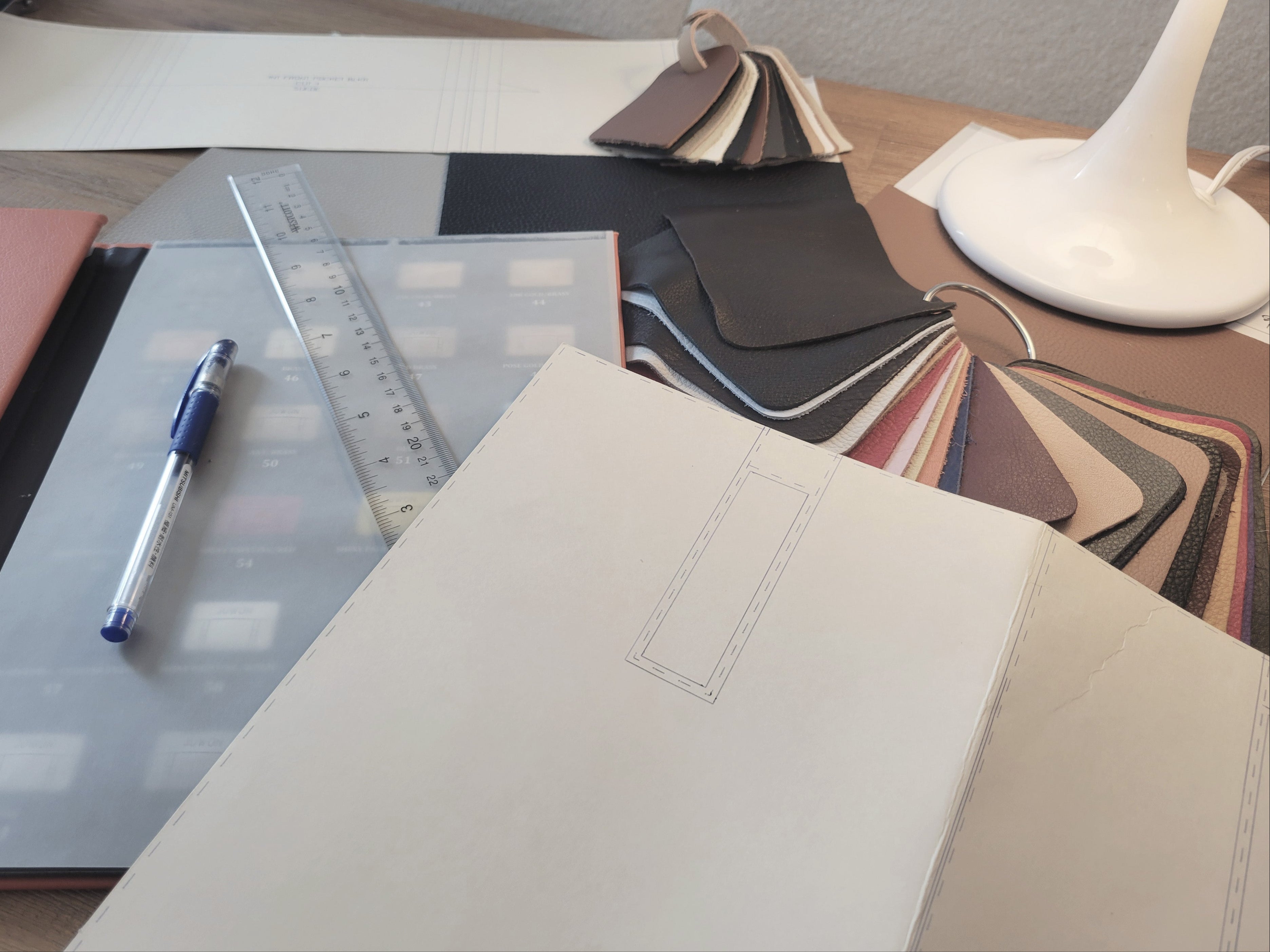 Desk with a notebook, pen, ruler, and color swatches