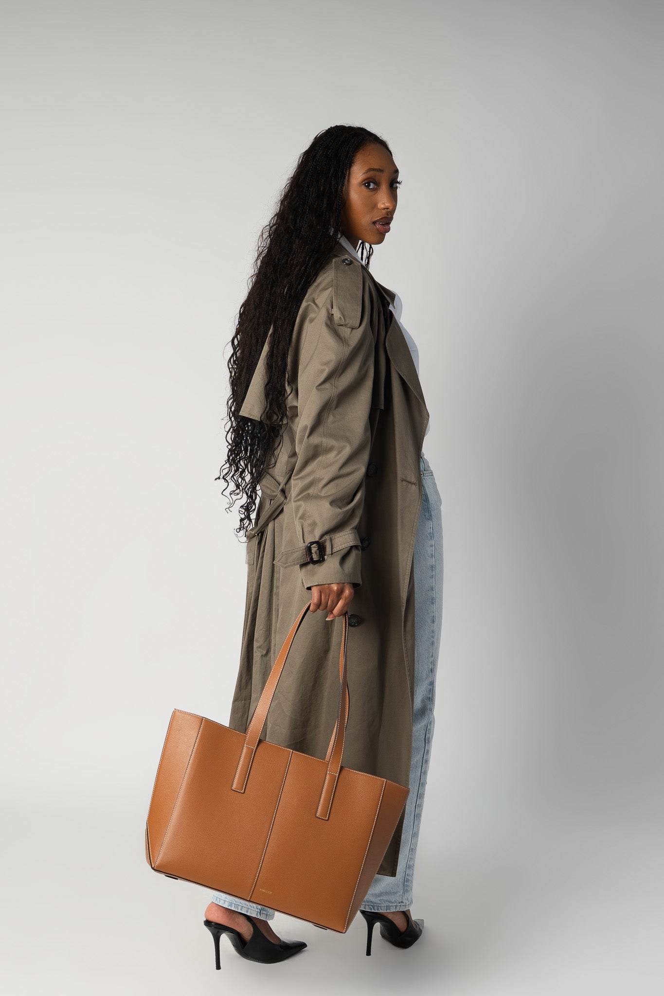 Model holding camel daely tote in fall outfit