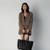 Model holding black daely tote in business casual outfit